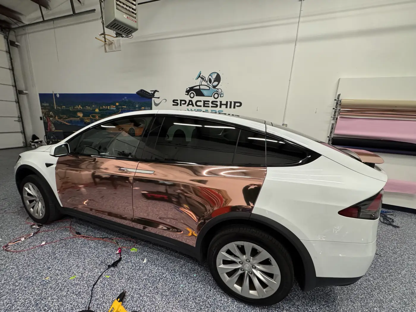 Doors finished, rear quarter still the car’s own white. This is the frame that shows what chrome does, because the thing it is being compared to is the same panel four feet away.